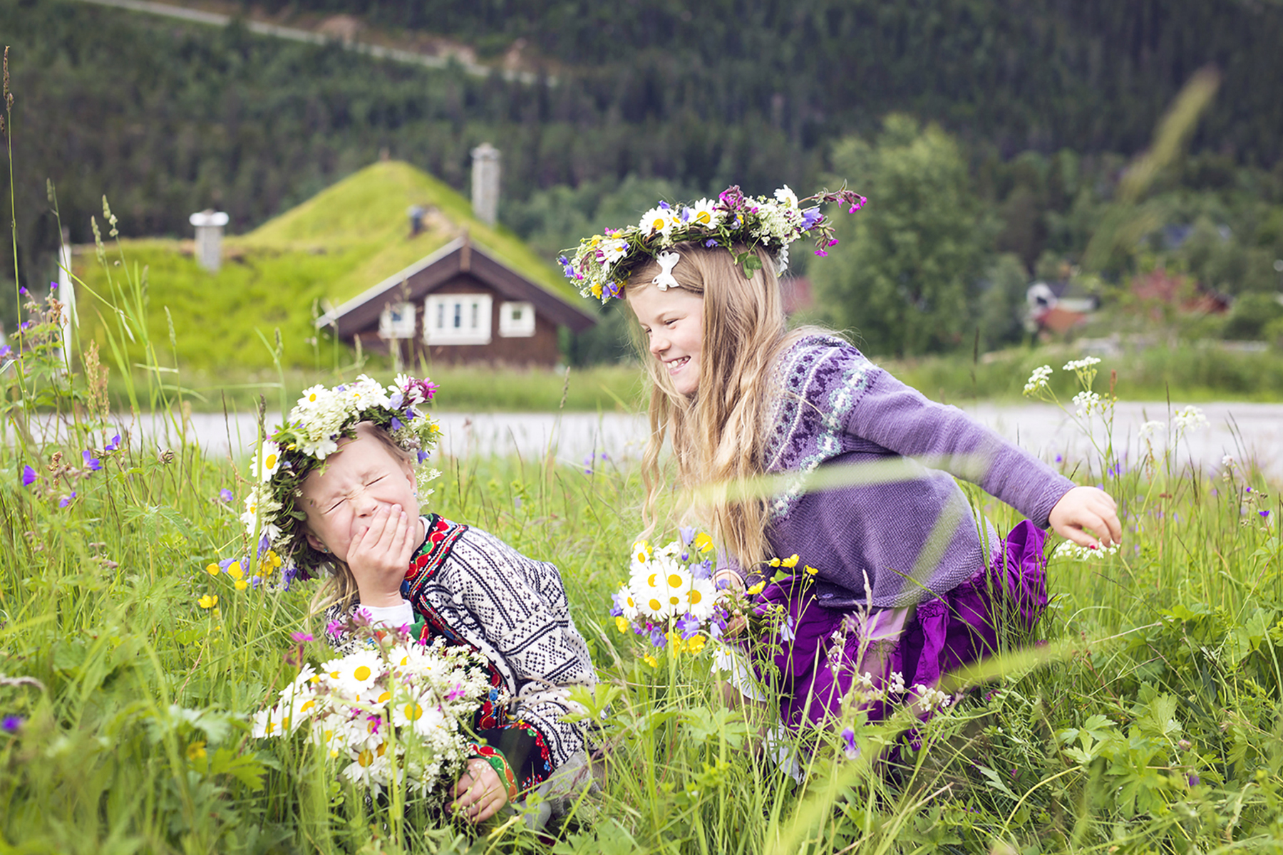 Barn med blomsterkranser i sommereng ved hytte — Haukeli Hytter og Hus