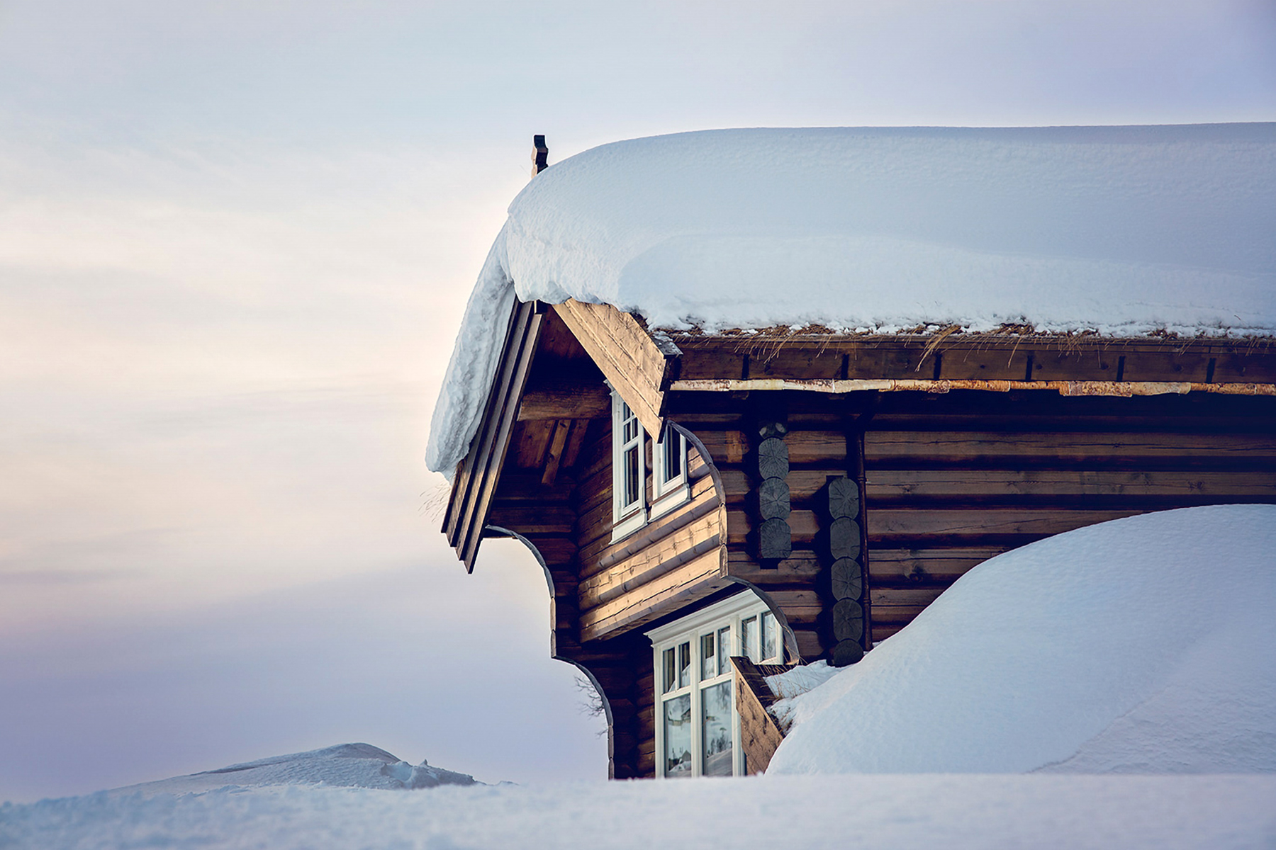 Snødekt laftehytte med stort tak — Haukeli Hytter og Hus
