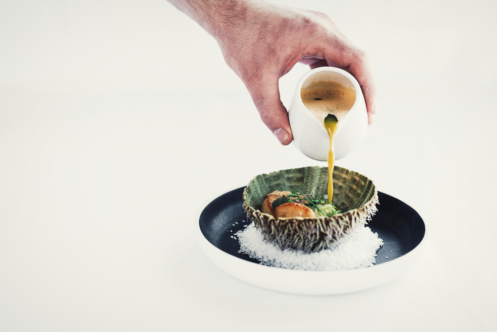 Hånd som heller saus over rett — Cornelius Sjømatrestaurant