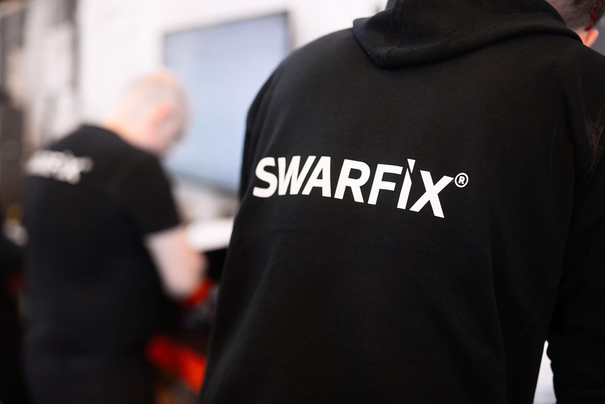 Swarfix-genser med logo i verkstedmiljø