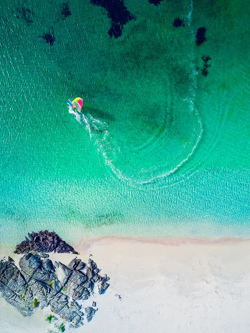 Åkra strand Karmøy — båt i turkis sjø, dronefotografering for Skudenes & Aakra Sparebank